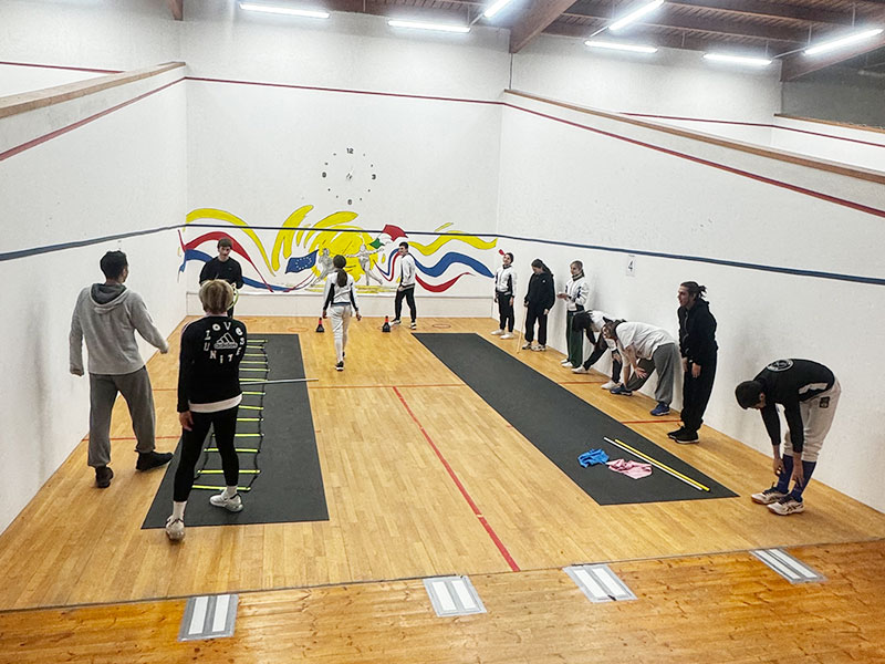 "Interazione tra maestri e allievi in palestra di scherma a Milano